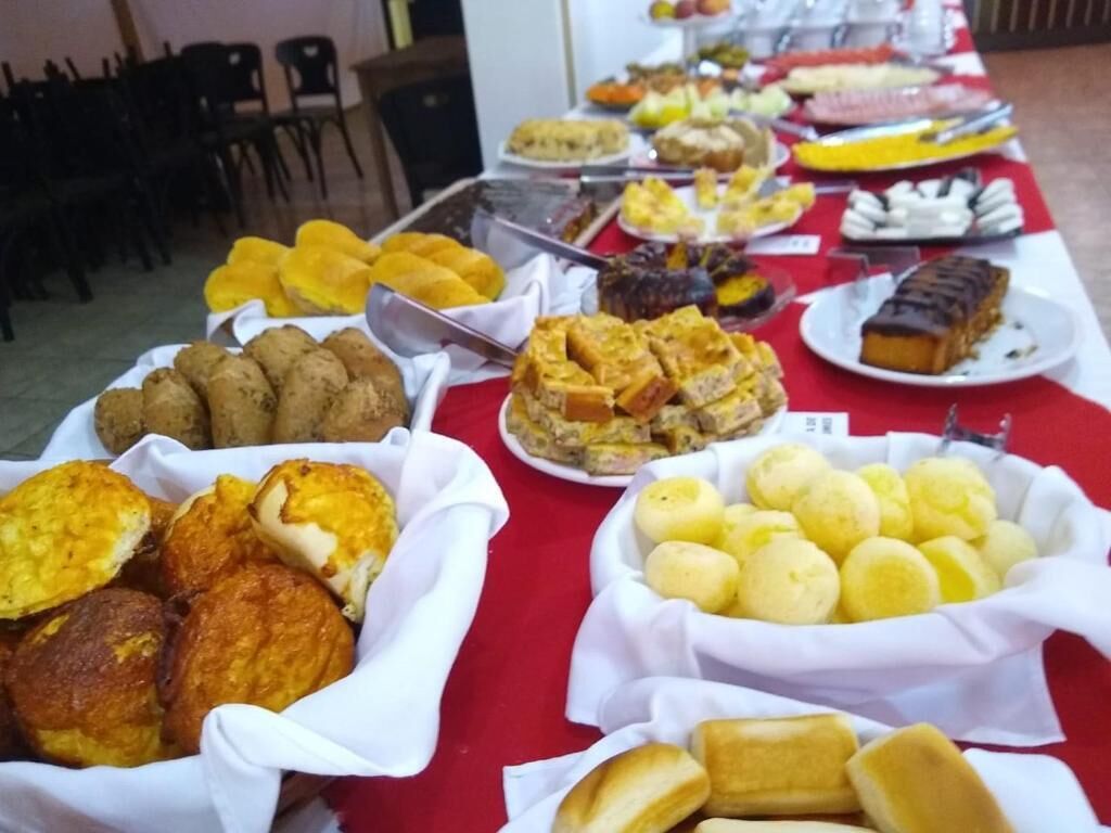 A buffet table with various food items including pastries, bread, and desserts.