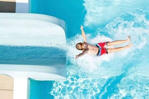 A child in a pool with a water slide. - Pousada Casablanca Águas de São Pedro (Aguas de Sao Pedro)