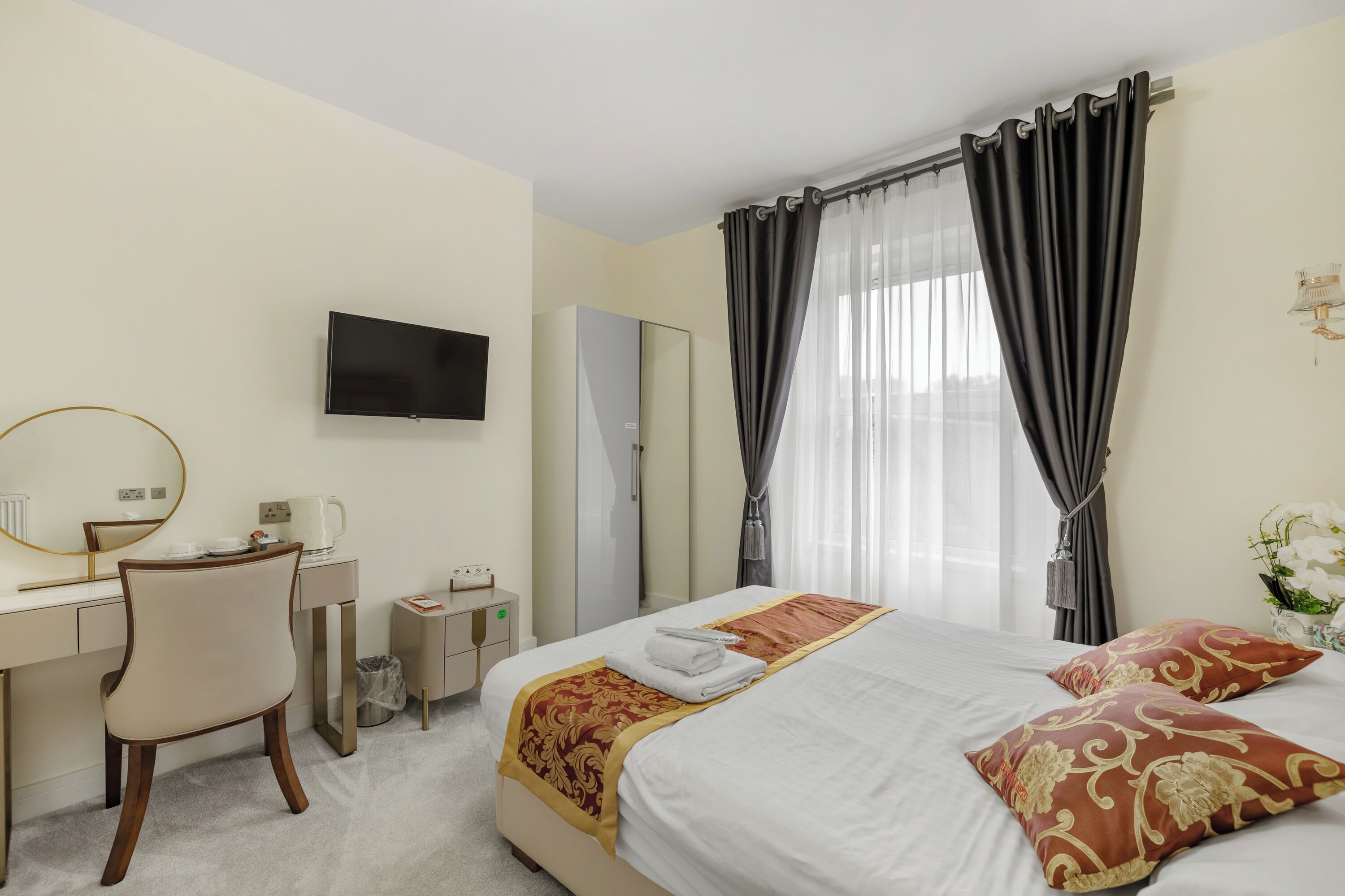 Una habitación de hotel con cama, escritorio, silla, televisor y baño.