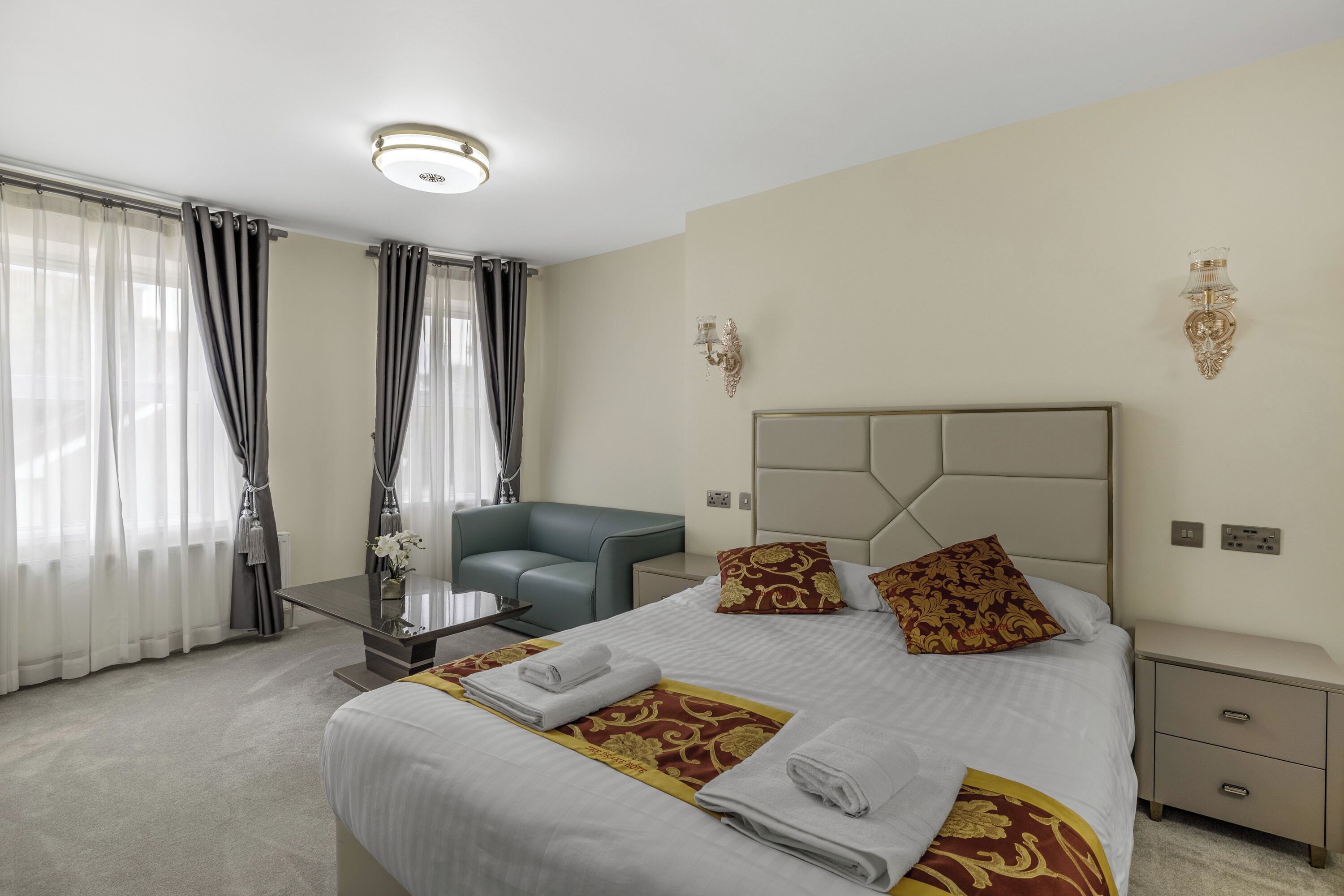 Une chambre d’hôtel avec un lit, un bureau, une chaise et une table de chevet.