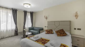 Une chambre d’hôtel avec un lit, un bureau, une chaise et une table de chevet.