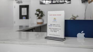 Un mostrador de recepción con un cartel que ofrece un descuento por reserva directa para el hotel The Drake.