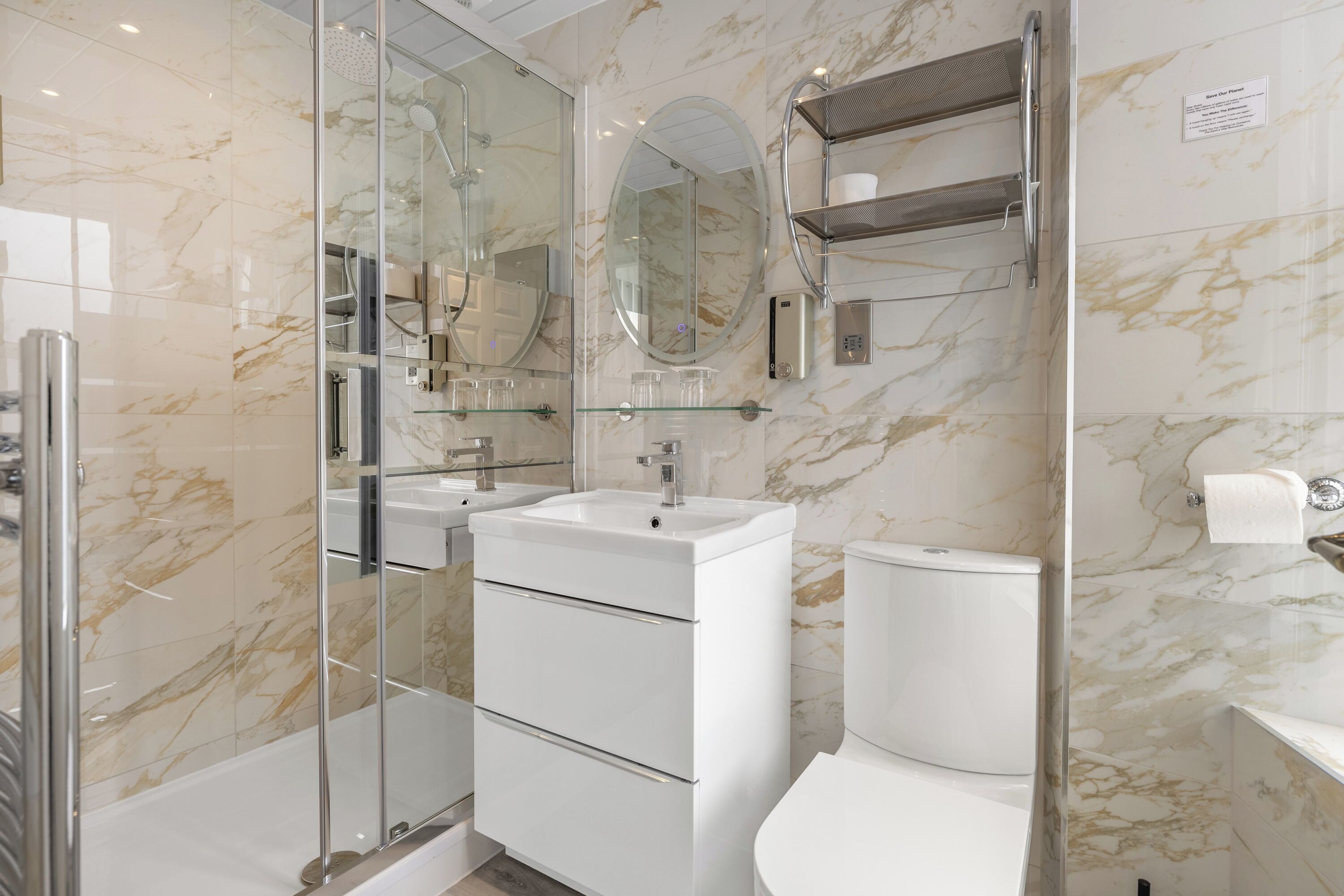 A modern bathroom with a glass-enclosed shower, a white sink, and a toilet.
