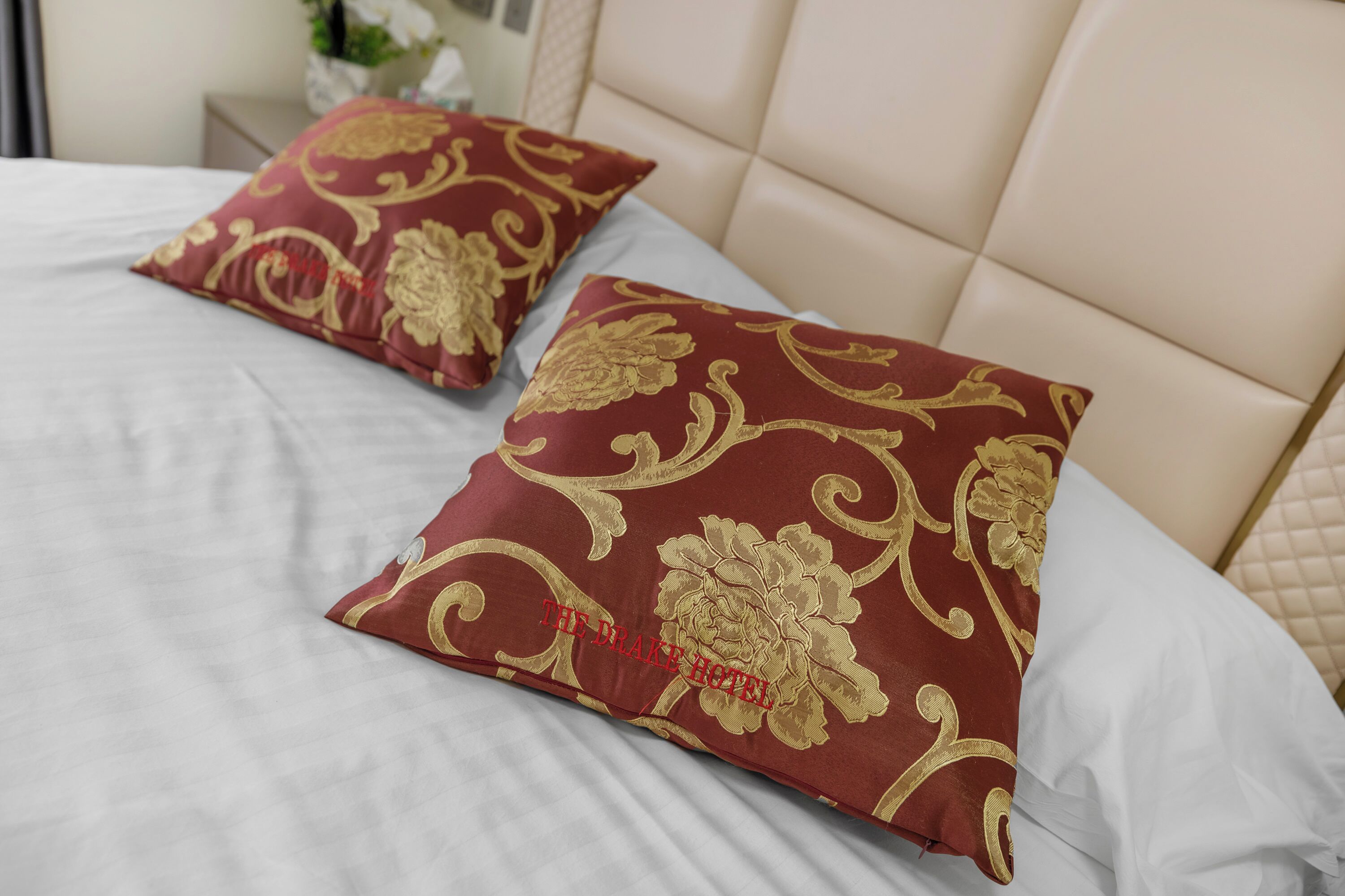 A bed with two decorative pillows and a headboard.