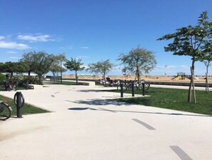 Explore the scenic park with a bike-friendly path leading to a playground and a nearby beach area.