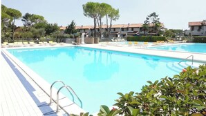 A swimming pool with lounge chairs and a clear sky. - Villa in village with swimming pool 6 beds (Bibione)