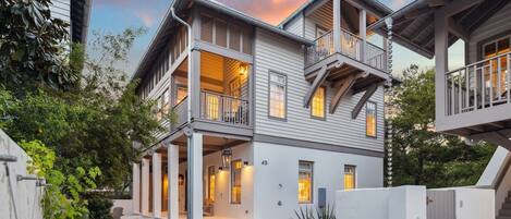 A two-story house with a covered porch and a balcony.