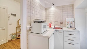 Una cocina con electrodomésticos blancos, un lavamanos y una encimera.