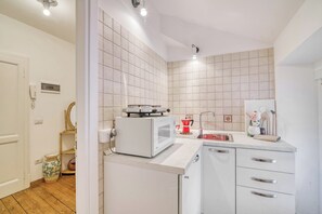 A kitchen with white appliances, a sink, and a countertop.