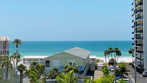 A coastal view with a beach, a hotel, and a tall building.