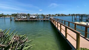 A marina with docked boats, a wooden pier, and a clear blue sky.