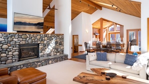 A spacious living area with a stone fireplace, leather seating, and a wooden coffee table.