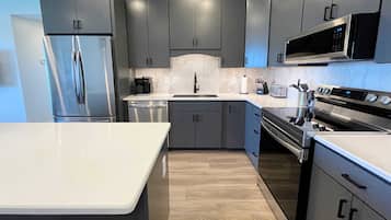 Een koelkast, een magnetron, een kookplaat, een vaatwasser