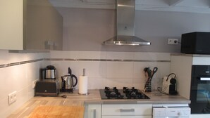 A modern kitchen with a stainless steel range hood, a Bosch dishwasher, and a microwave. - Basque country between sea and mountains, quiet ground floor apartment with garden  (ustaritz)