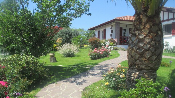 A garden pathway leading to a building with a red-tiled roof and white walls. - Basque country between sea and mountains, quiet ground floor apartment with garden  (ustaritz)