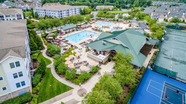 A residential area with a swimming pool, tennis courts, and a covered pavilion. - Coastal Charm at Bayside, Golf Cart Access, Pools (Selbyville)