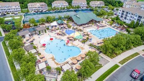 A resort with multiple swimming pools, a tennis court, and a variety of outdoor seating areas. - Coastal Charm at Bayside, Golf Cart Access, Pools (Selbyville)