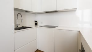 A modern kitchen with white cabinetry, a stainless steel sink, and a black countertop. - San Gallo Luxury by Mmega (Florence)
