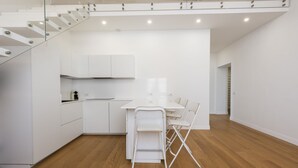 A modern kitchen with white cabinets, a dining table, and chairs. - San Gallo Luxury by Mmega (Florence)