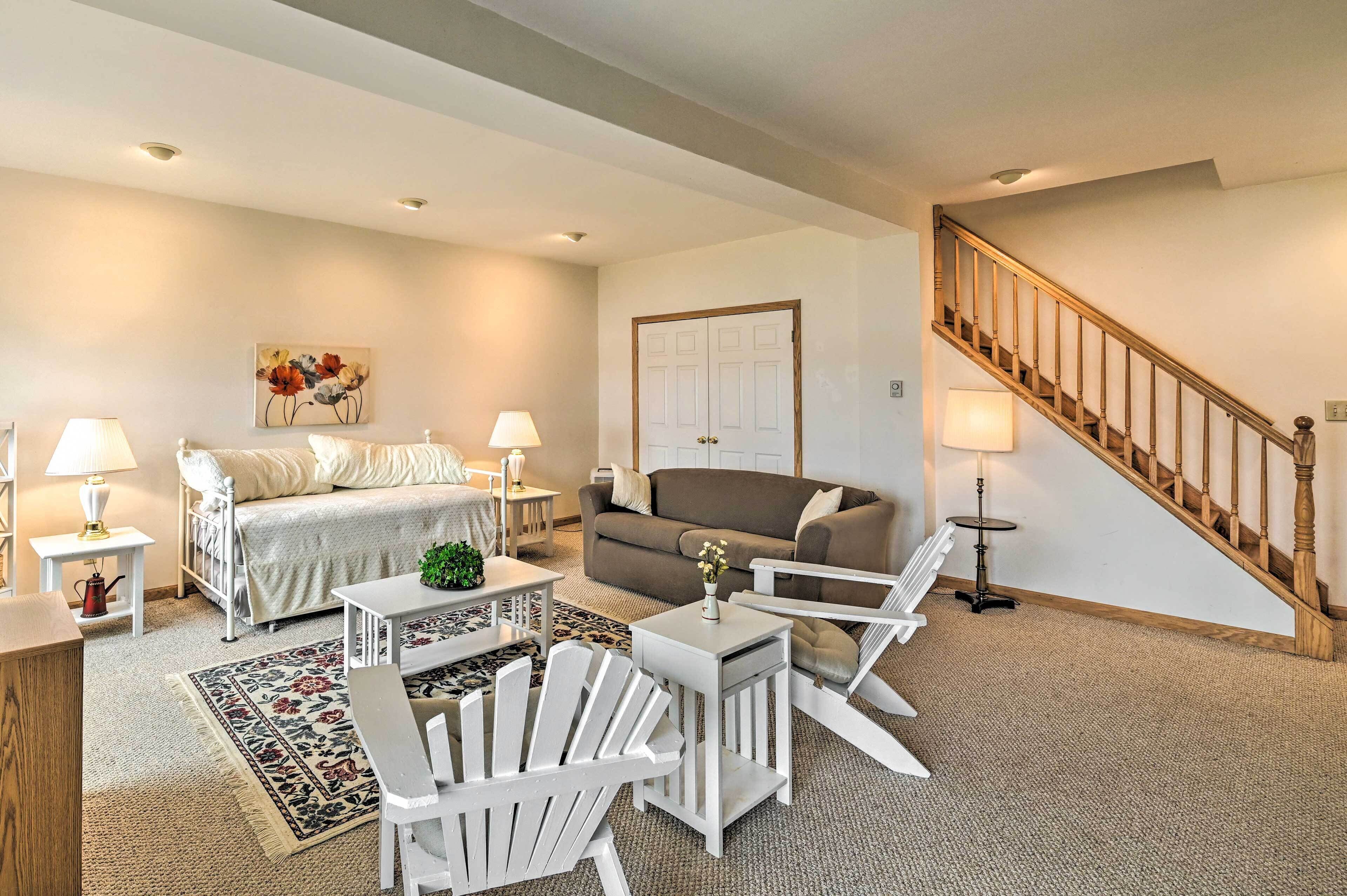 A living room with a sofa, two chairs, a coffee table, a lamp, and a staircase. - Lakefront Broadalbin Getaway w/ Deck + Kayaks (Broadalbin)