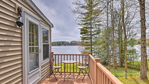 A wooden deck with a table and chairs, overlooking a lake and surrounded by trees. - Lakefront Broadalbin Getaway w/ Deck + Kayaks (Broadalbin)