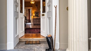 A grand entrance with a wooden floor, a black boot, and a white column. - Luxury Country Estate in West Cork (Bandon)
