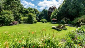 A well-maintained garden with a lawn, two sun loungers, and a small gazebo. - Luxury Country Estate in West Cork (Bandon)