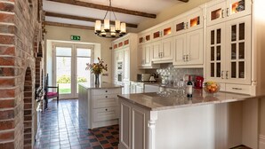 Een keuken met witte kasten, een centraal eiland en een kroonluchter.
