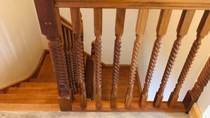 Una escalera de madera con barandilla y balaustres.