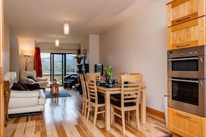 Een moderne keuken met houten kastjes en roestvrijstalen apparatuur.
