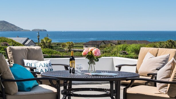 A patio with a table and chairs overlooking the ocean. - Large house with adjoining cottage close to Waterville (Waterville)
