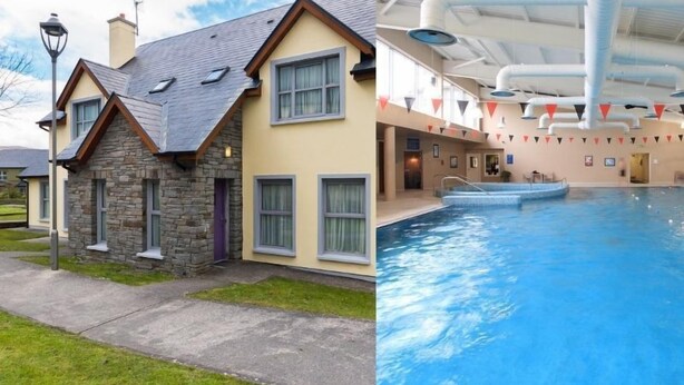 A two-story stone house with a sloped roof and a swimming pool with a covered area.
