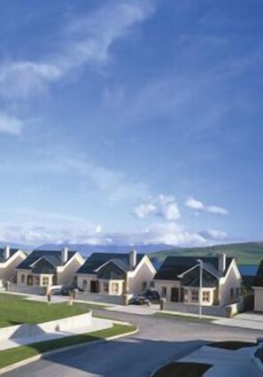 Una hilera de casas modernas con tejados a dos aguas y un cielo azul despejado.