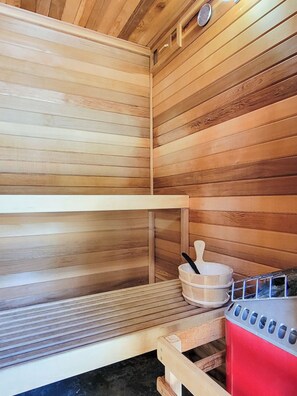 A sauna with wooden walls and a metal bench.