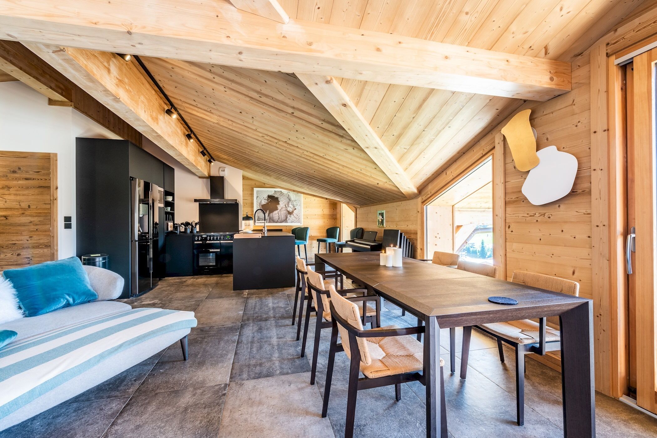A modern log cabin interior with a dining area, kitchen, and living space.