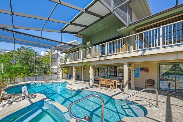 A pool area with a glass ceiling, outdoor seating, and a view of the ocean. - 🏖️Private Pool with Backyard Oasis-Canal Front-Osprey Retreat🏖️ (Fort Myers Beach)