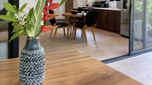 Una cucina moderna con mobili in legno, un'area pranzo con tavolo e sedie, e un'ampia finestra.