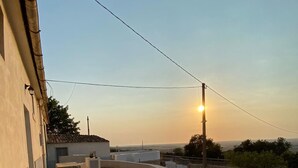 Une terrasse sur le toit, avec un sol en béton, un petit muret et une vue sur l’horizon.