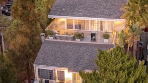 A two-story house with a flat roof, large windows, and a balcony.