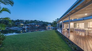 A modern house with a wooden deck, a swimming pool, and a well-maintained lawn. - Wesley Court No. 21 Noosa Sound (Noosa Heads)