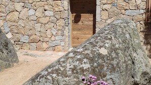 A stone building with a wooden door and a small window.