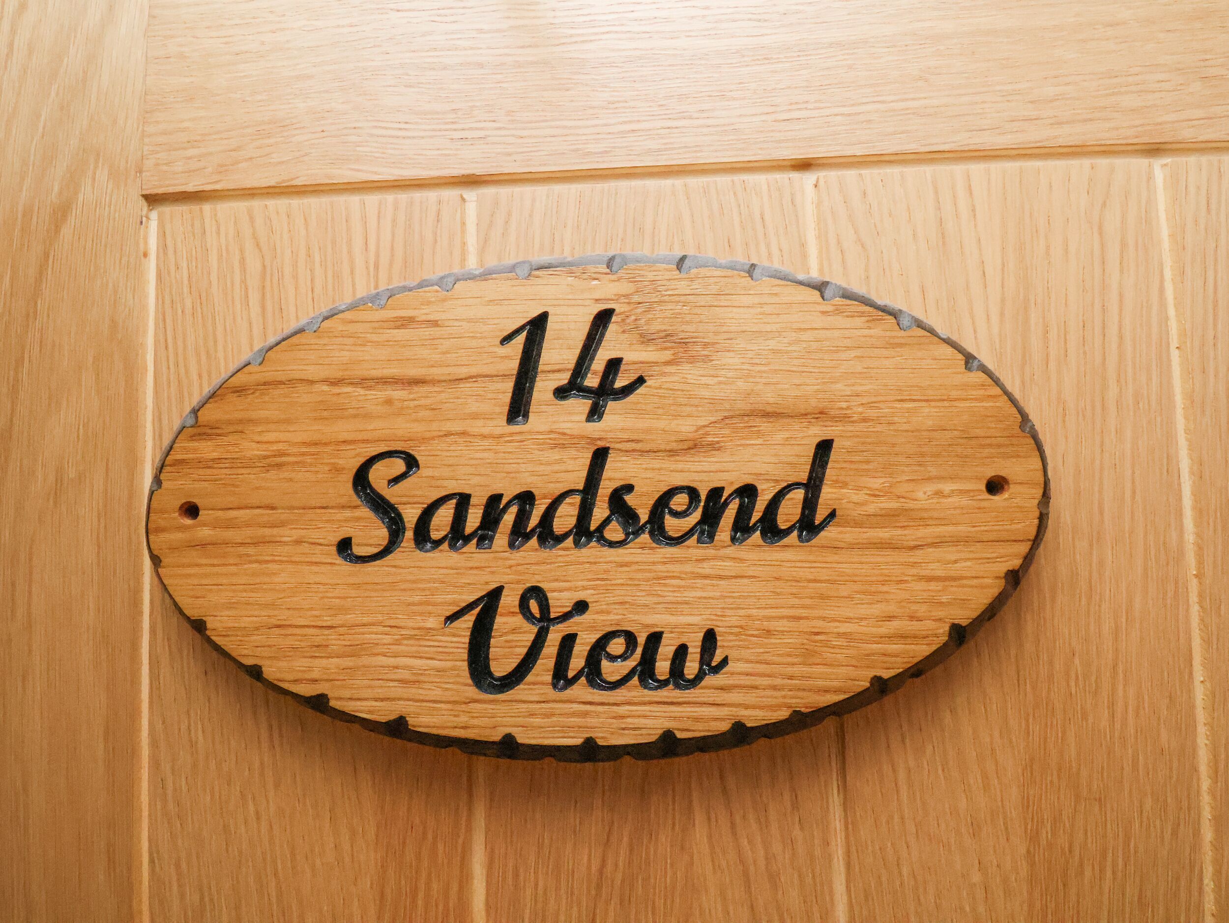 Un letrero de madera con el texto '14 Sandend View' en una puerta.