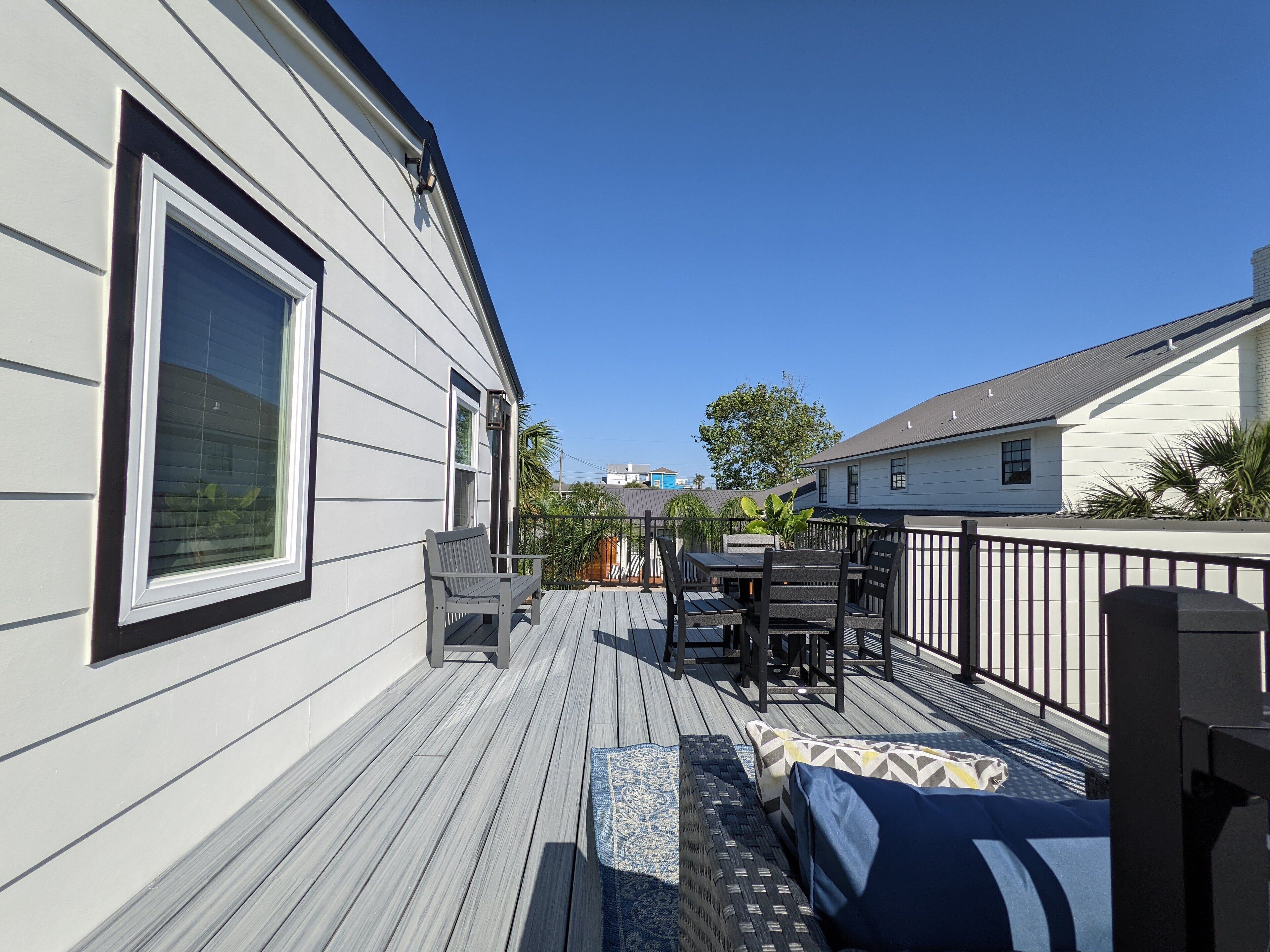 A deck with a table and chairs, a bench, and a railing.