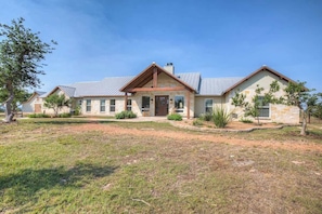 A two-story house with a stone facade, a front porch, and a well-maintained lawn. - Lux Ranch w/Pool-Hot-Tub Near Fred! (Fredericksburg)