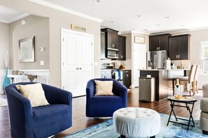 Relax in this stylish living space with a kitchen area, comfortable seating, and a large mirror.