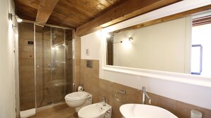 A bathroom with a glass-enclosed shower, two bidets, a sink, and a mirror. - Hotel Residence Noto Marina e Spa (Noto)
