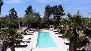 A rectangular pool with lounge chairs and palm trees. - Hotel Residence Noto Marina e Spa (Noto)