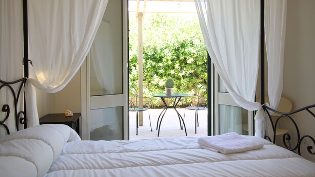 A bedroom with a bed, a small table, and a chair. - Hotel Residence Noto Marina e Spa (Noto)