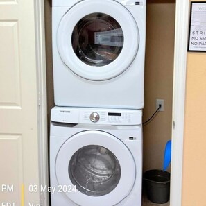 A stacked washer and dryer unit in a laundry room.