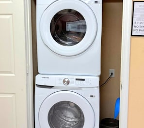 Una lavadora y secadora apiladas en un cuarto de lavado.
